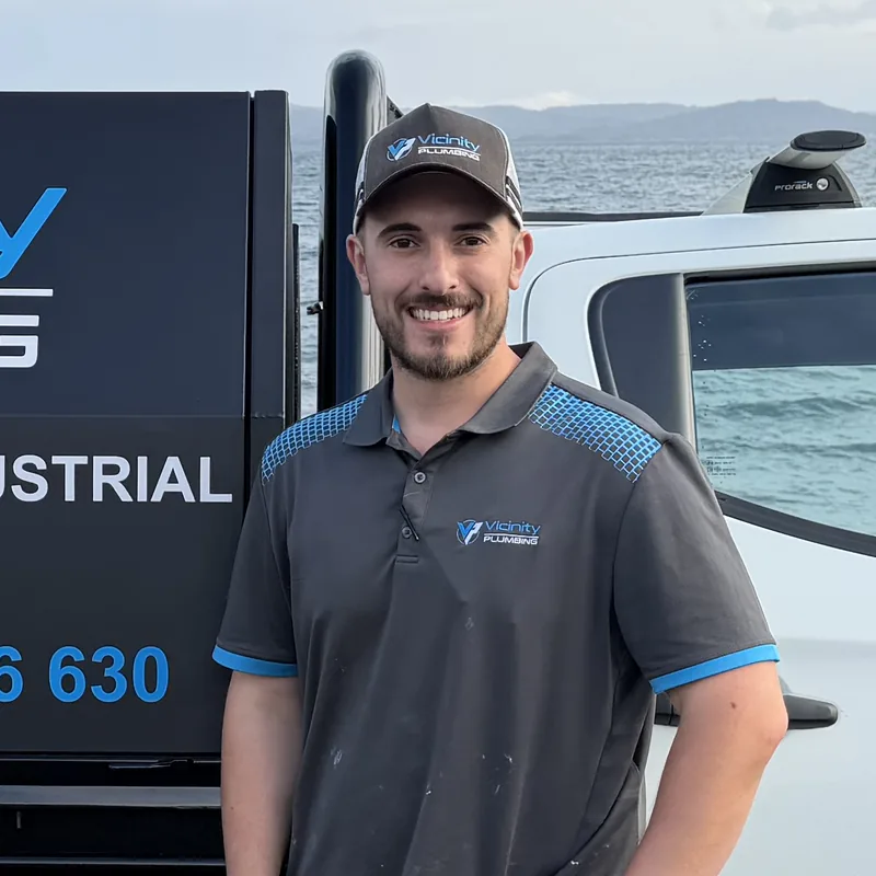 Jake, owner of Vicinity Plumbing, standing beside his service ute at Carey Bay